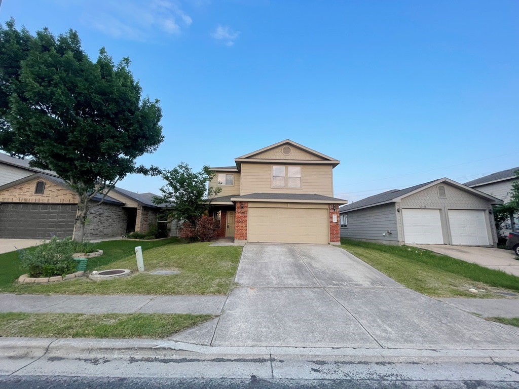 a front view of a house with a yard and garage