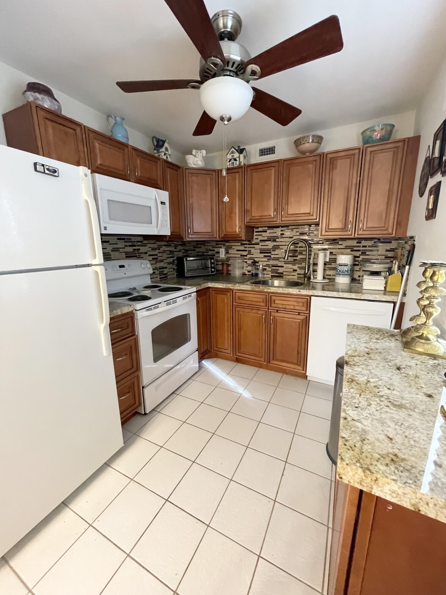 a kitchen with stainless steel appliances granite countertop a sink and a refrigerator