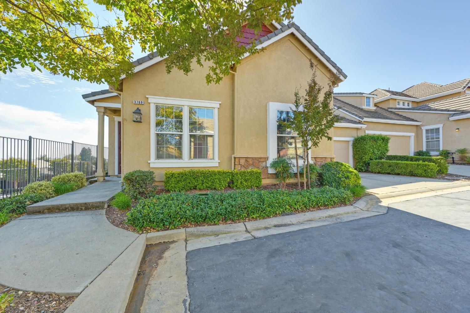 a front view of a house with a yard and potted plants