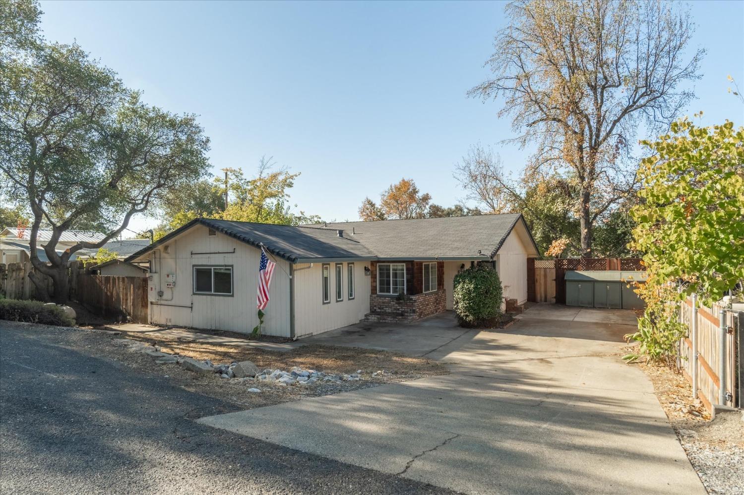 a view of a house with a large tree and a yard