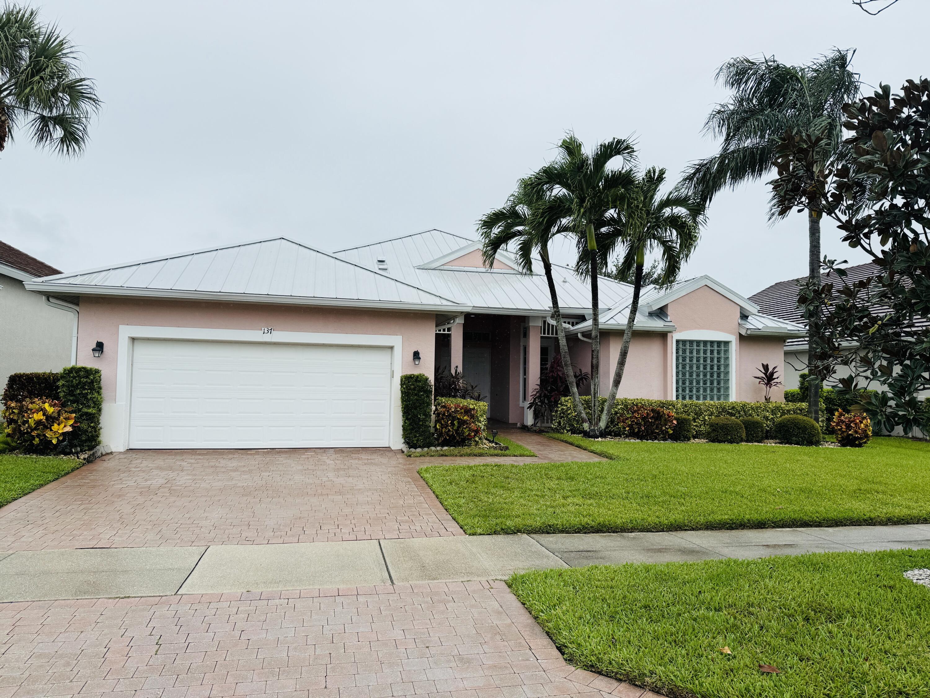 a front view of a house with a garden and trees