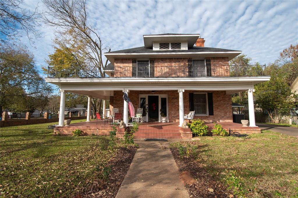 front view of a brick house with a yard