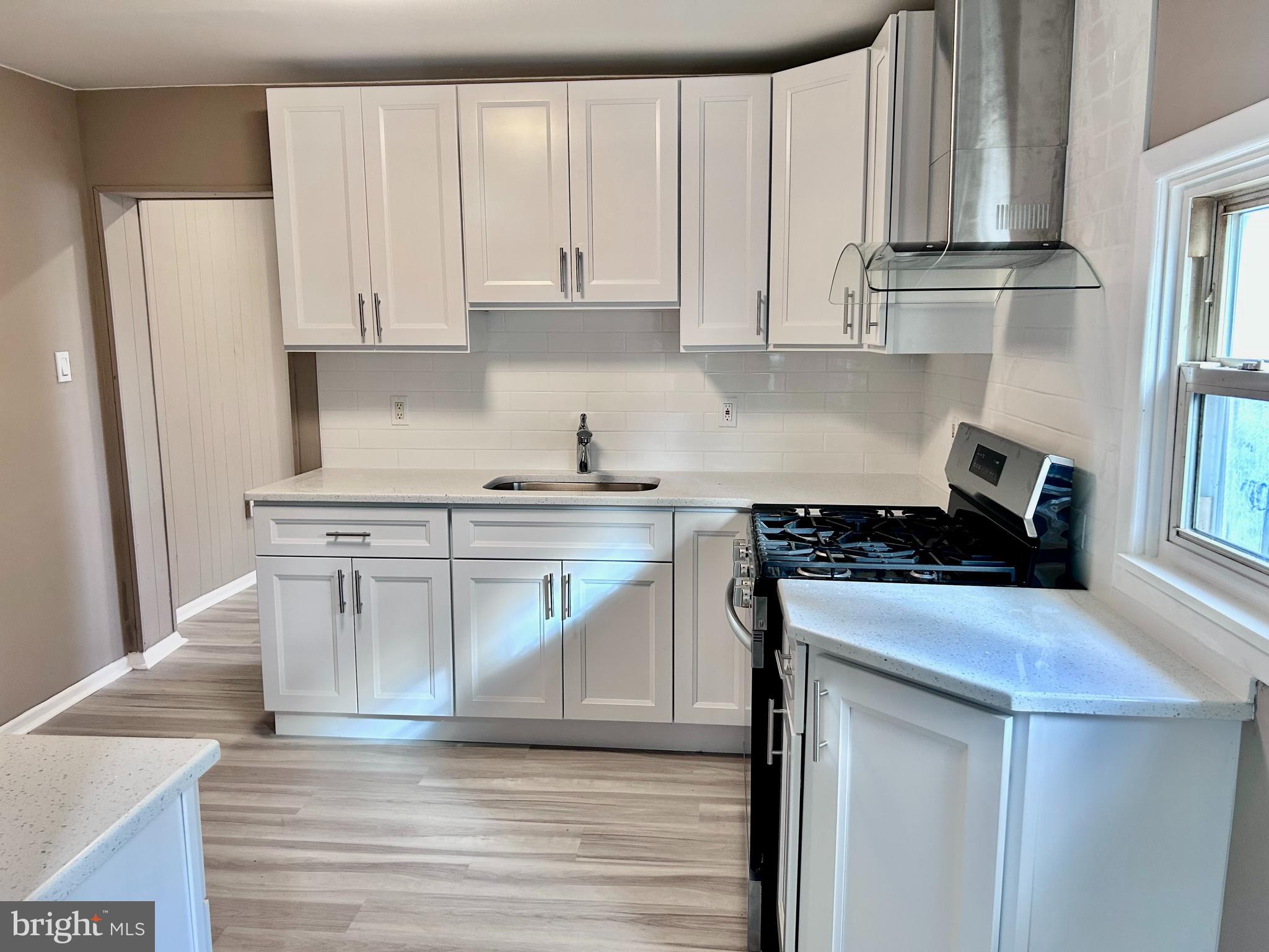 a kitchen with stainless steel appliances granite countertop a stove a refrigerator and a white cabinets