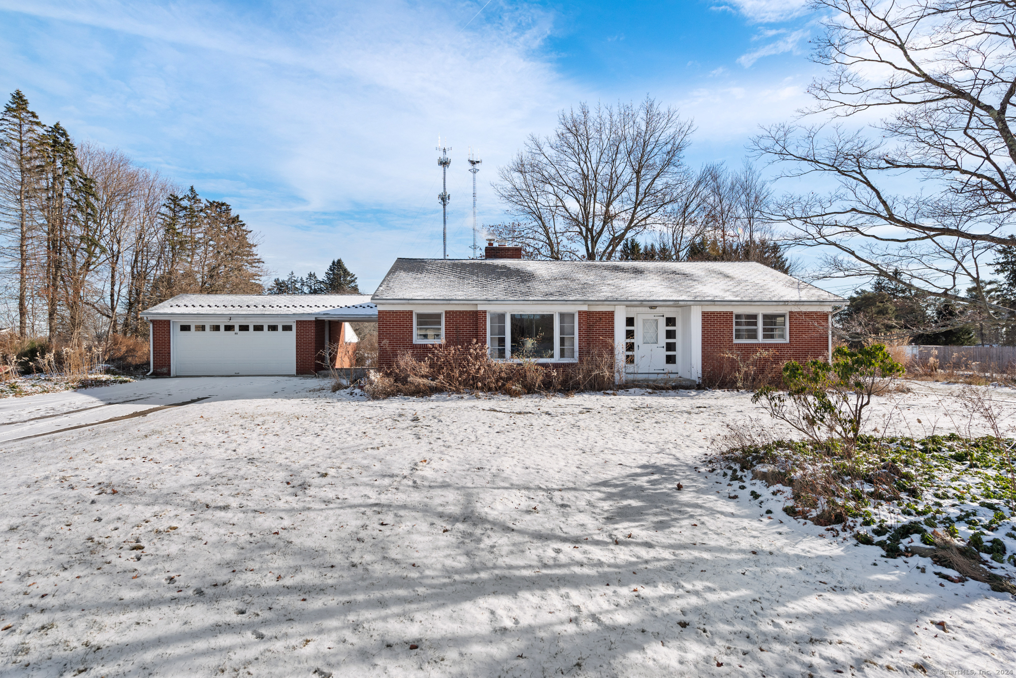 a front view of a house with a yard covered in snow