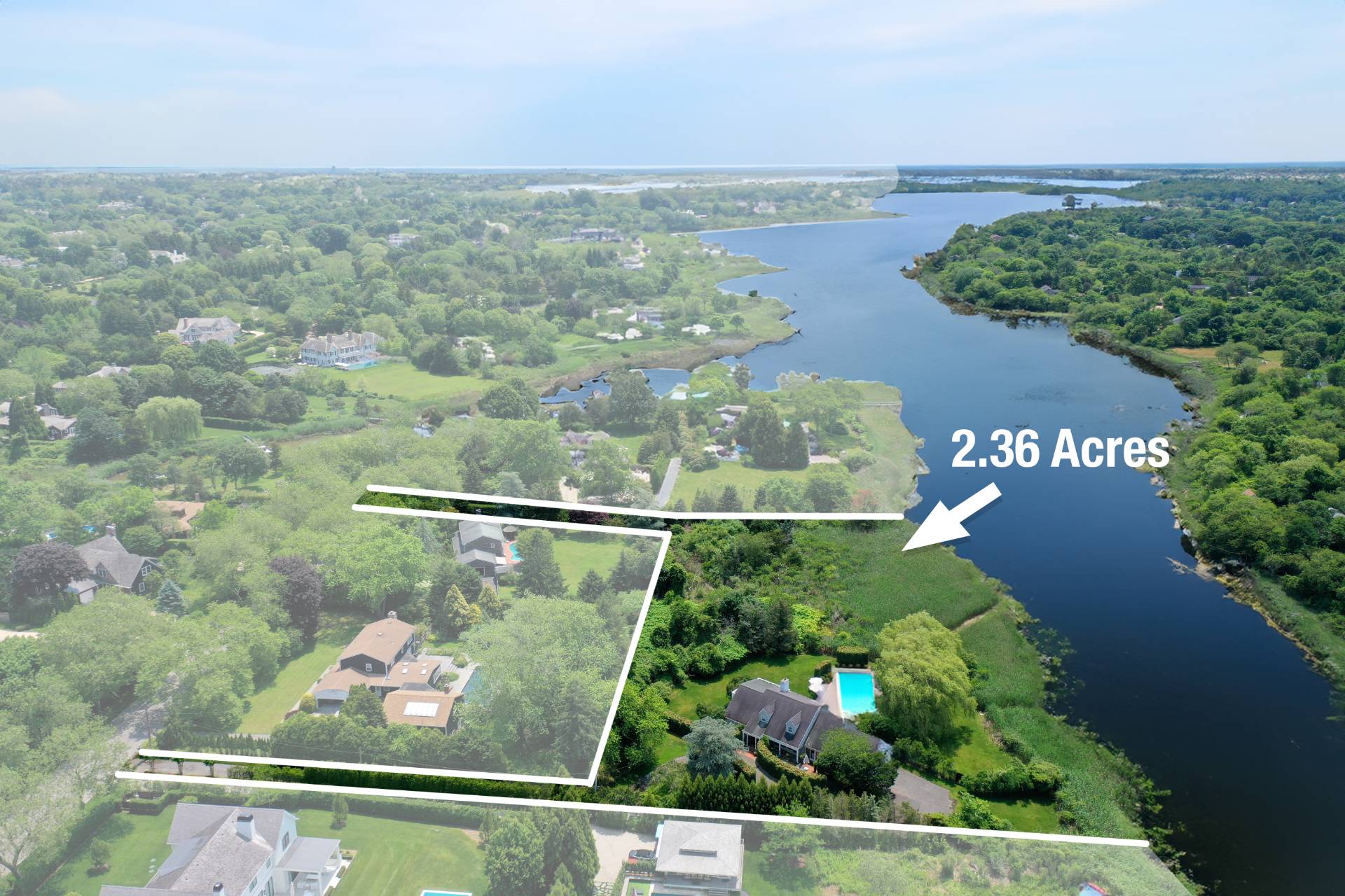 an aerial view of a house with a yard and lake view