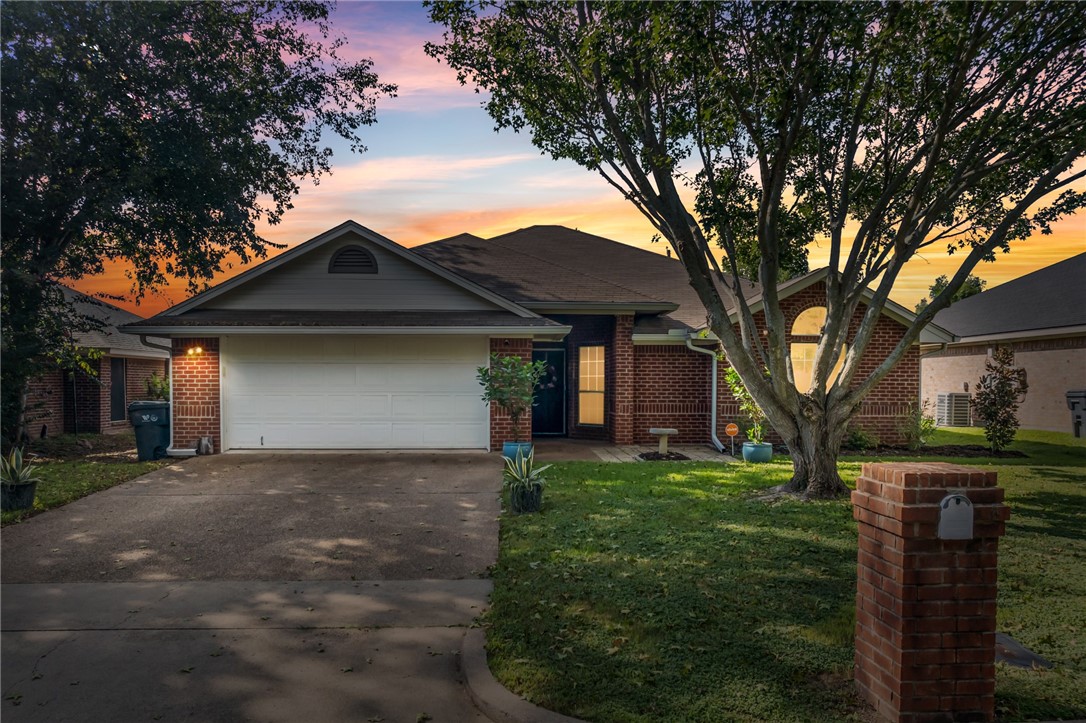 a front view of a house with a garden and trees