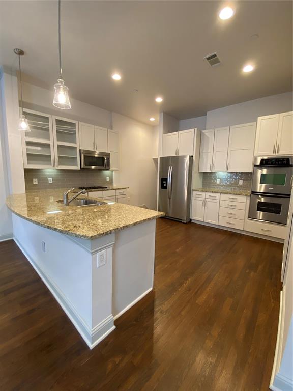 a kitchen with stainless steel appliances granite countertop a sink a stove top oven a counter space and cabinets