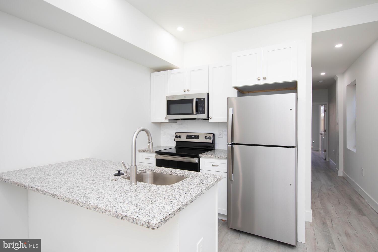 a kitchen with kitchen island a sink appliances and cabinets