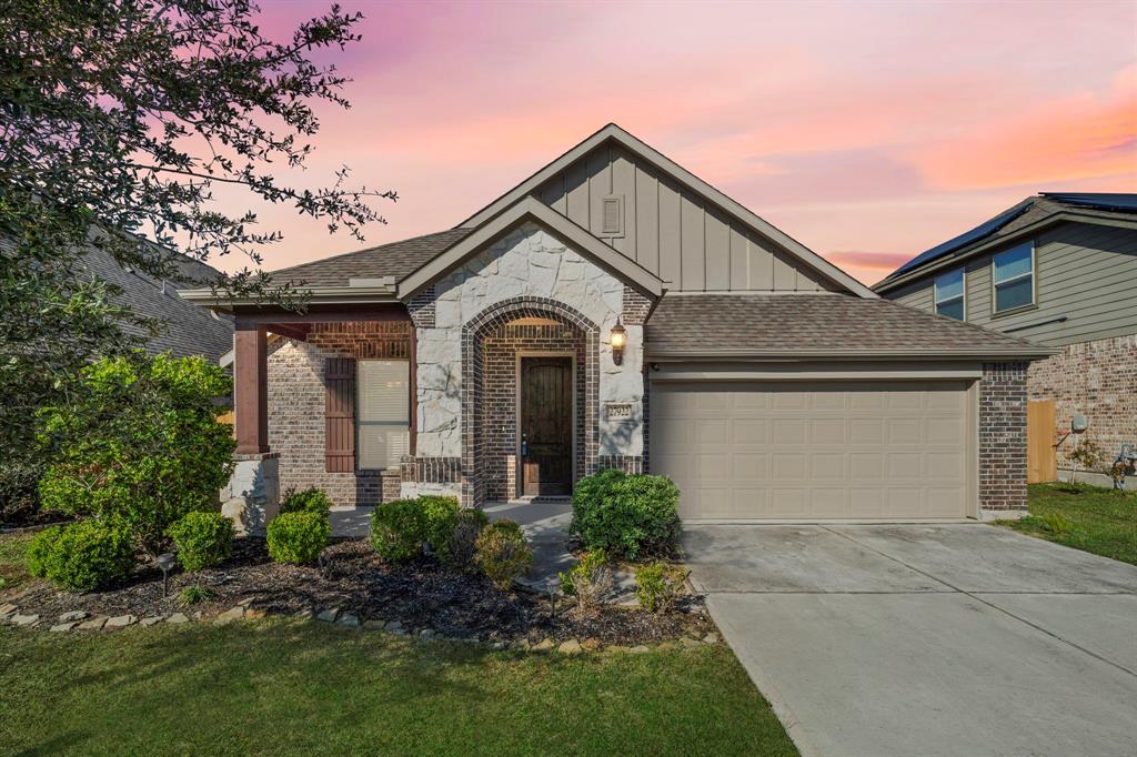 Experience the charm of this Gehan Home in Harmony Village, featuring stunning architectural details highlighted by a stone-and-brick façade. The inviting covered porch adds warmth to its curb appeal.