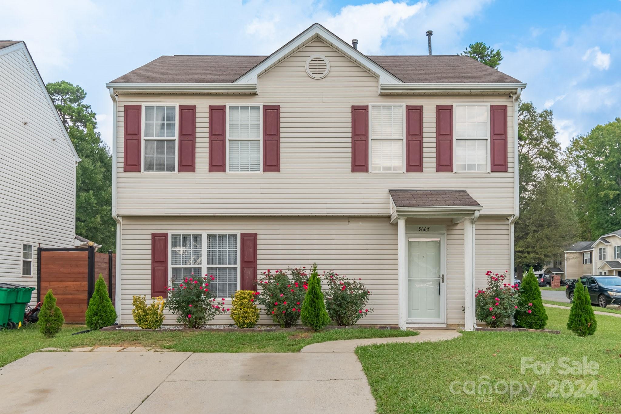 a front view of a house with a yard and potted plants