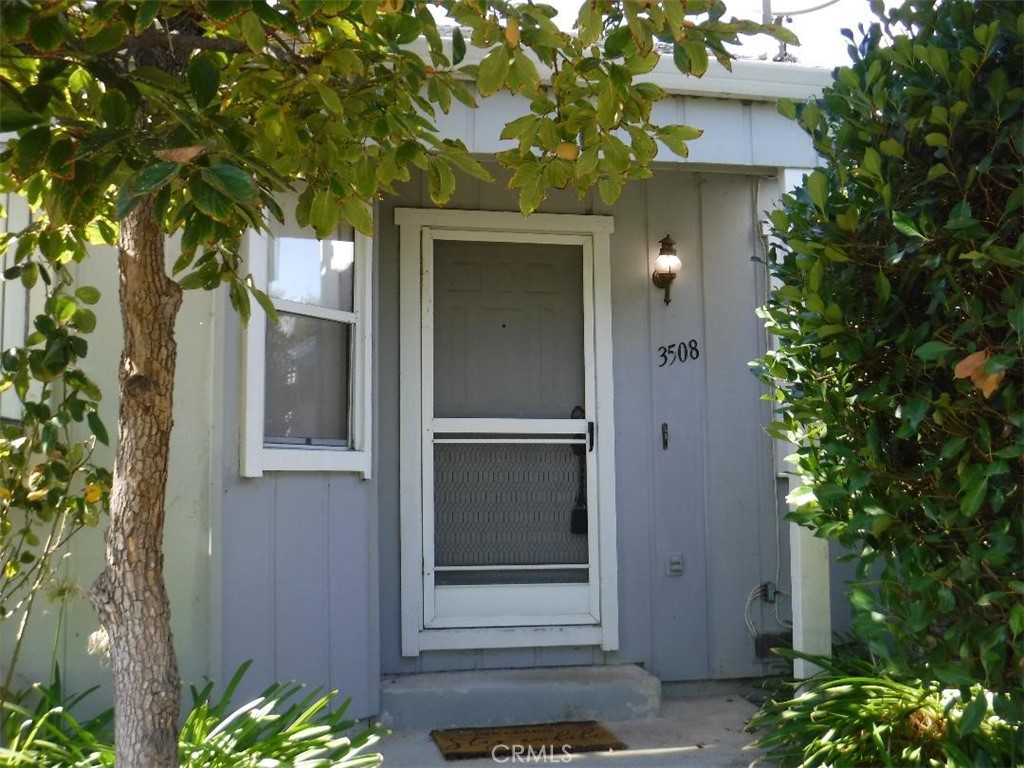 a front view of a house with a tree