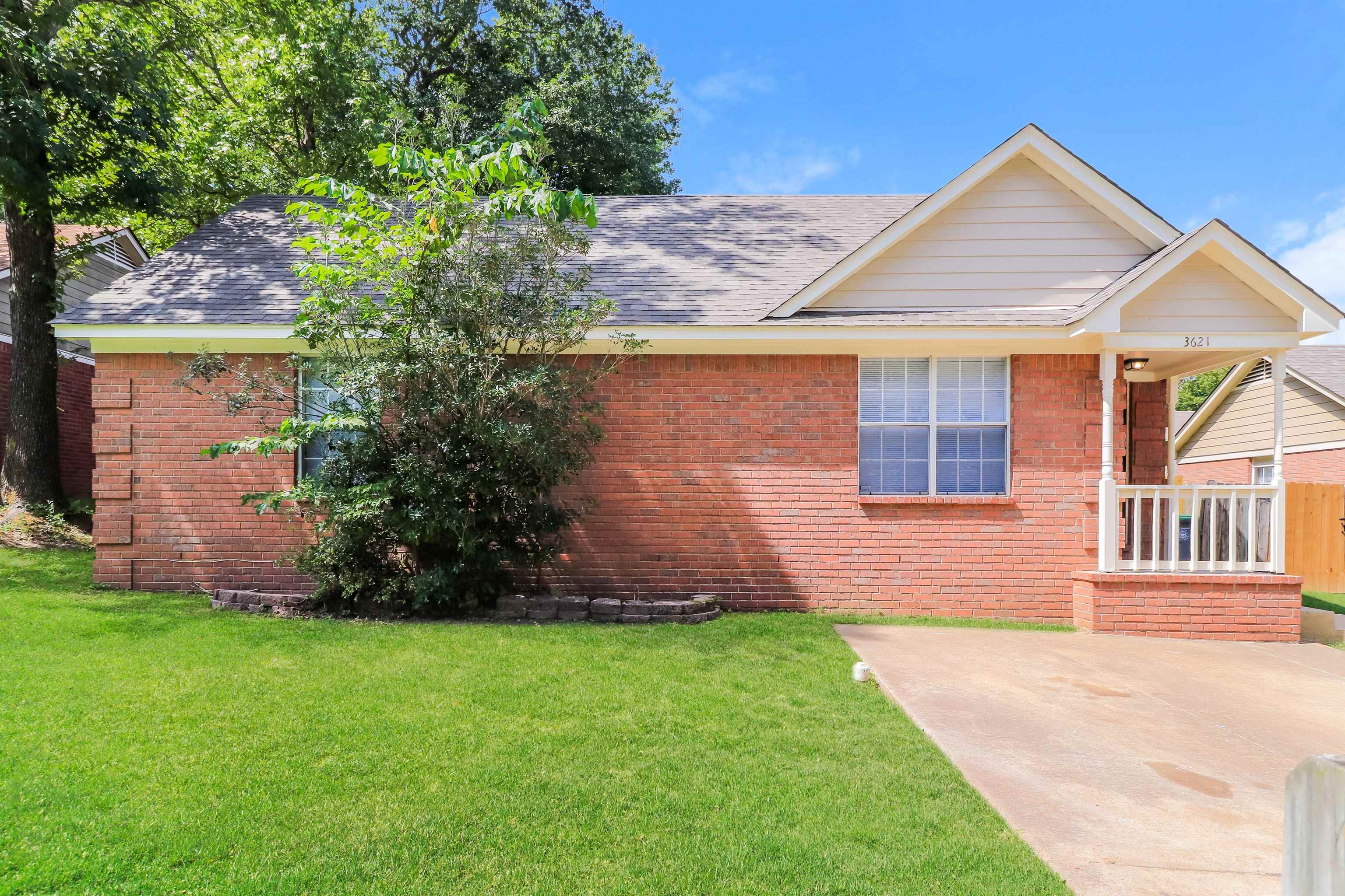 a front view of a house with a garden and yard