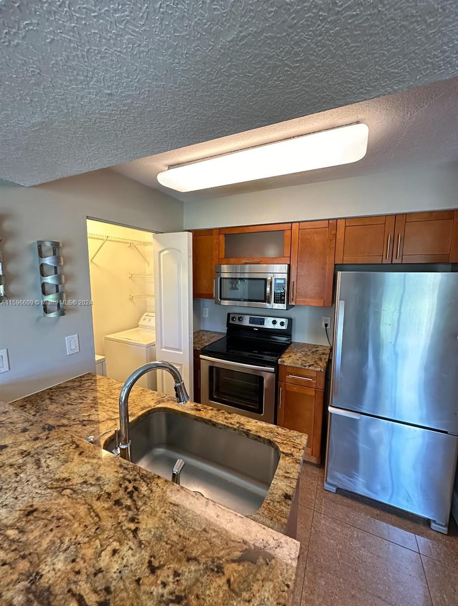 a kitchen with stainless steel appliances a refrigerator and a stove top oven