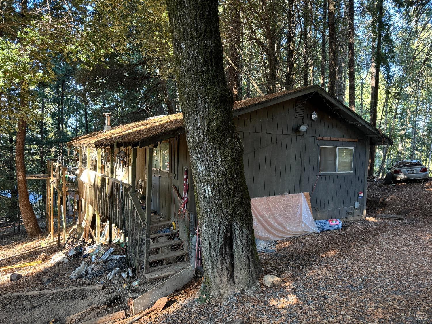 a backyard of a house with wooden fence and large trees