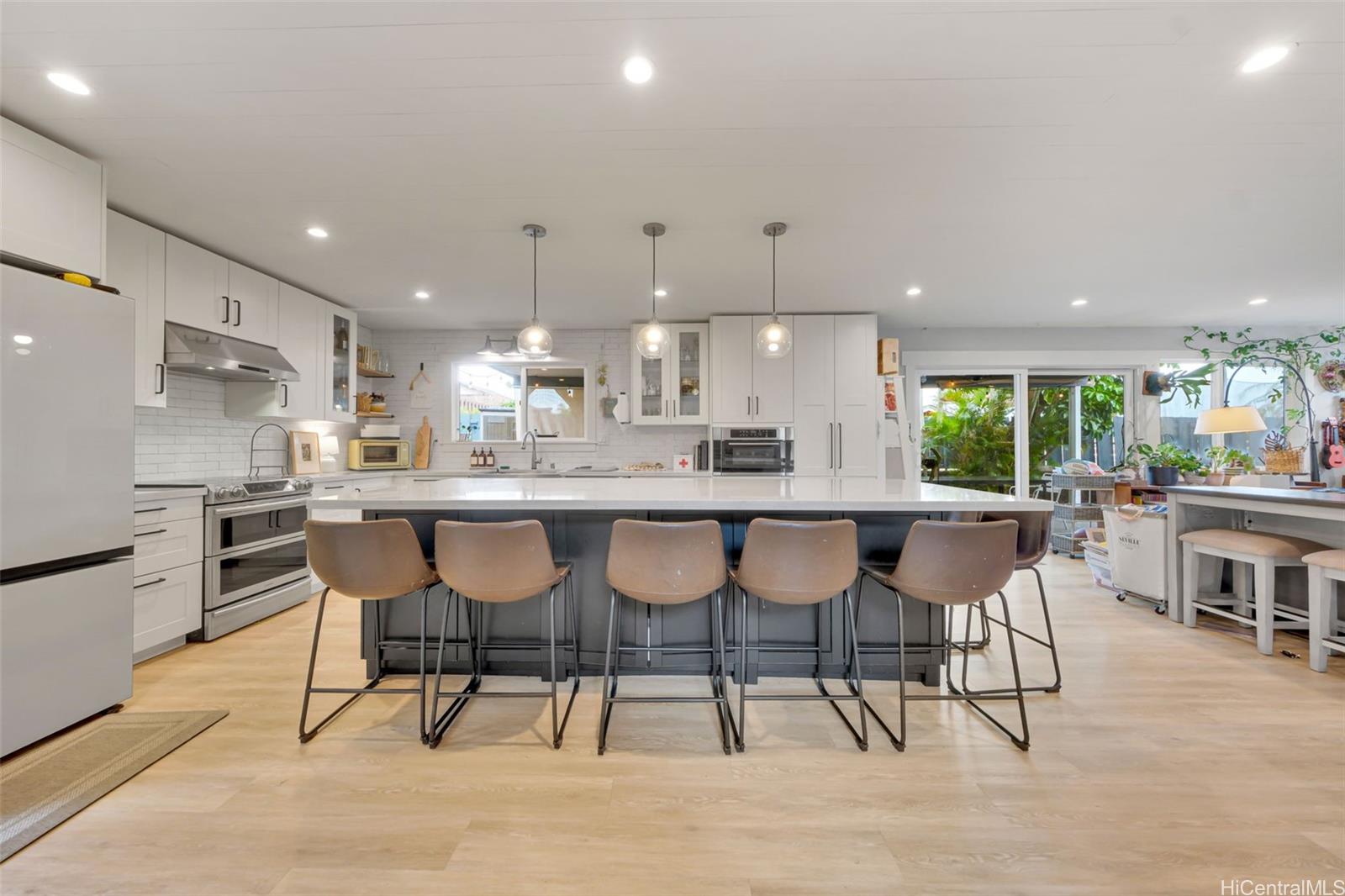 a kitchen with kitchen island a dining table and chairs