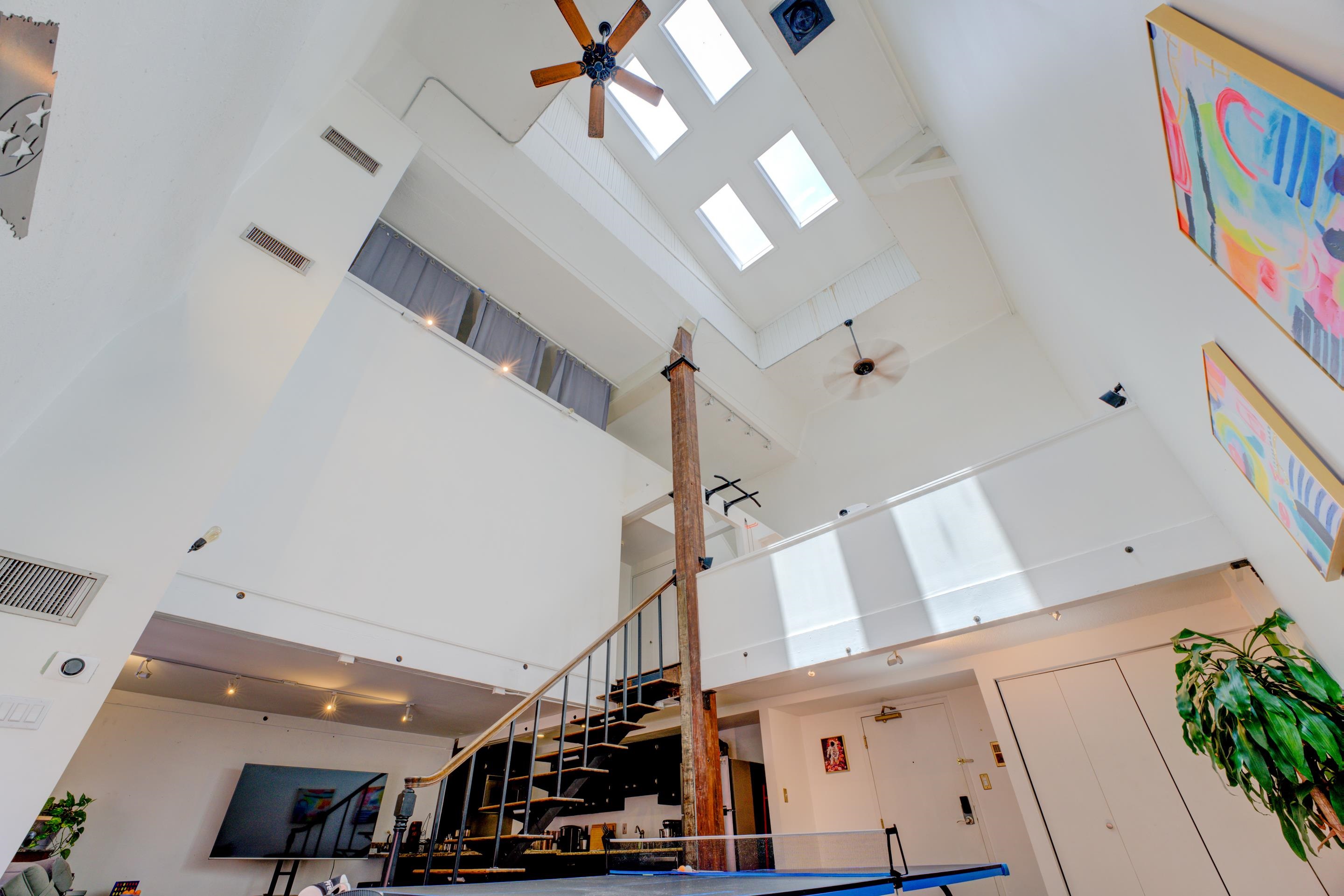 Living room featuring a towering ceiling and ceiling fan