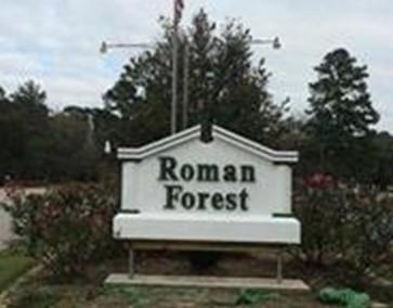 a view of a sign board with yard and green space