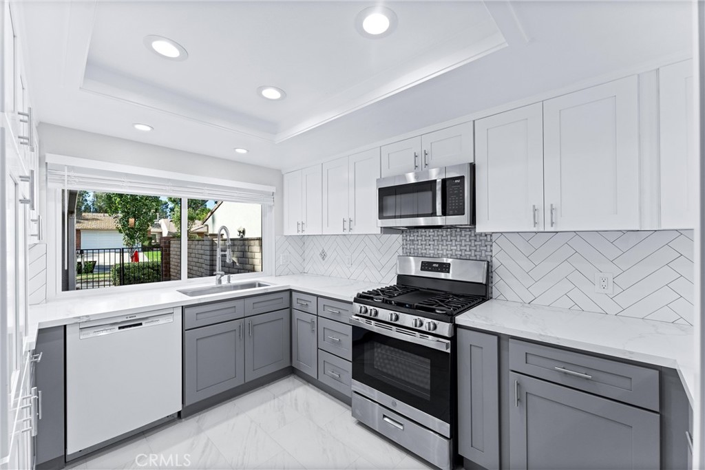 a kitchen with sink a microwave and cabinets