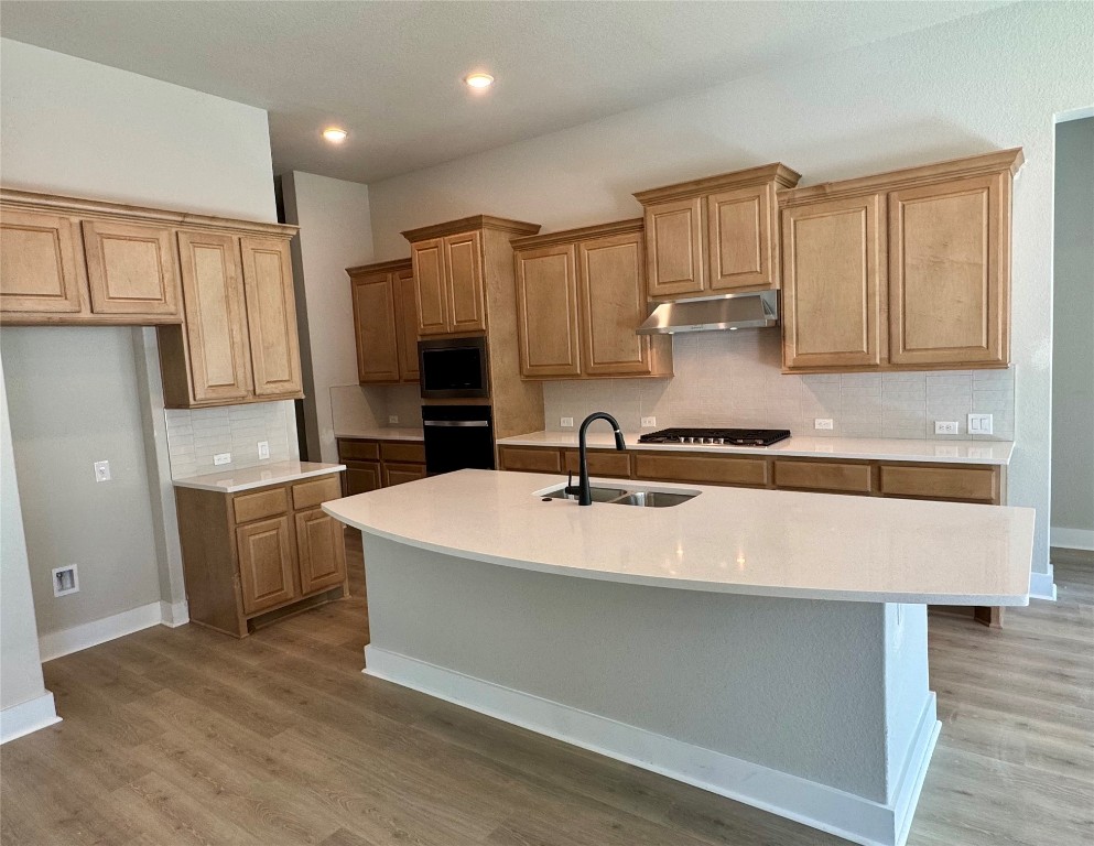 a kitchen with a sink cabinets and wooden floor