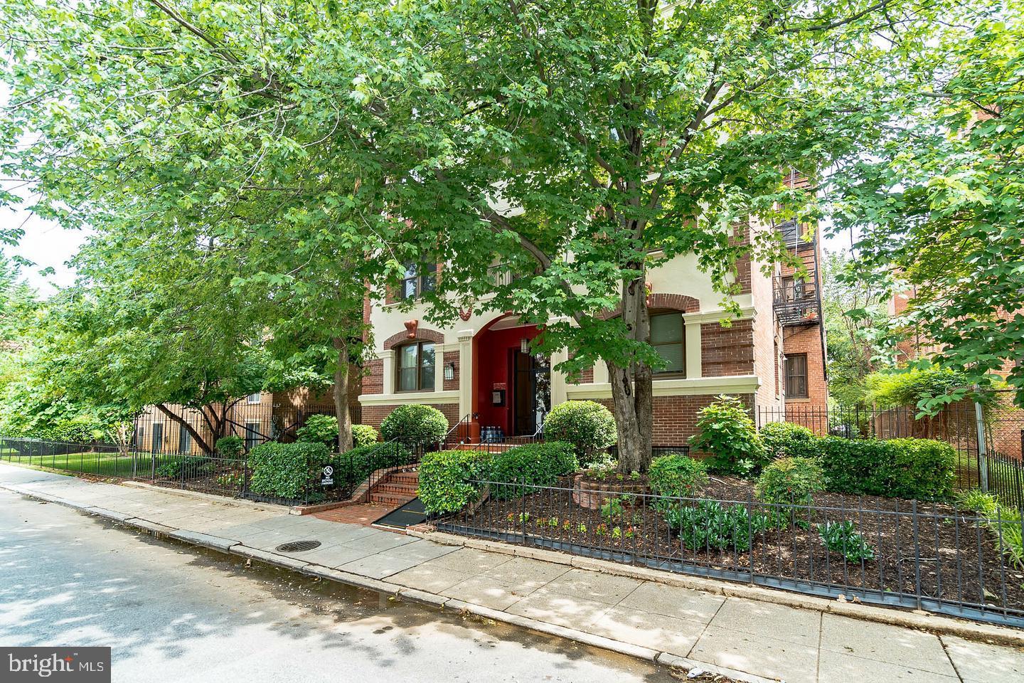 a front view of a house with a yard and potted plants