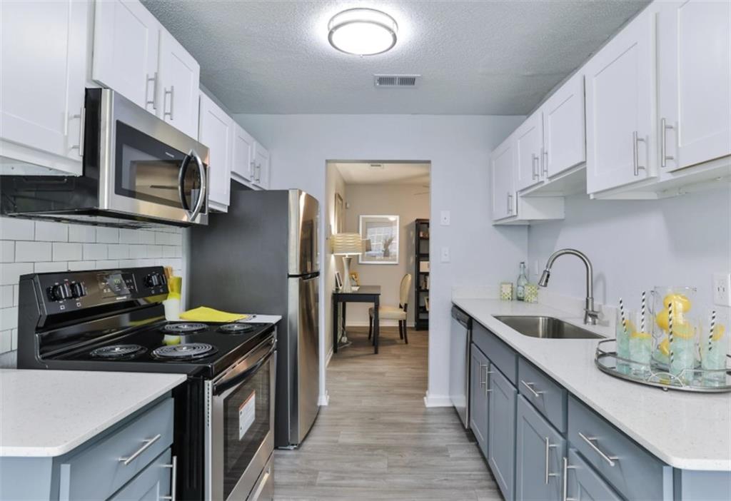 a kitchen with stainless steel appliances a stove sink microwave and cabinets