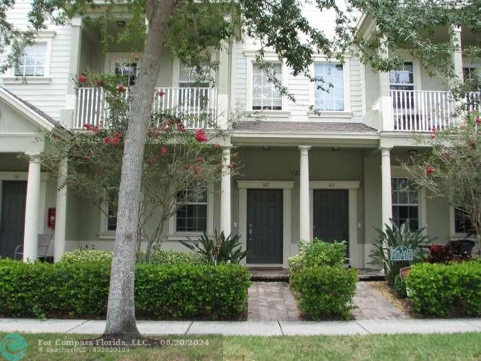 front view of a house with a small yard and potted plants