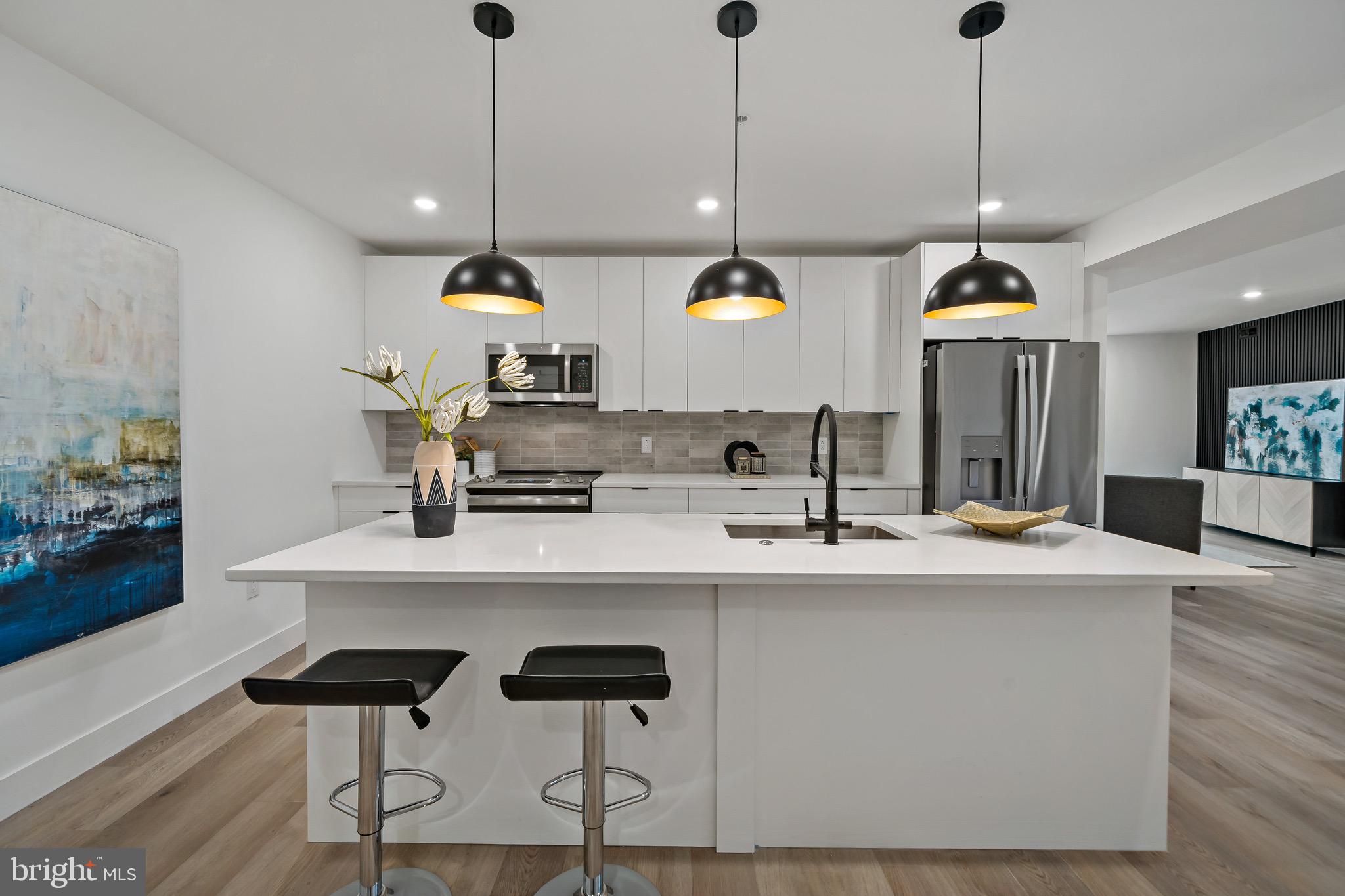 a kitchen with kitchen island stainless steel appliances a sink a center island and a center island