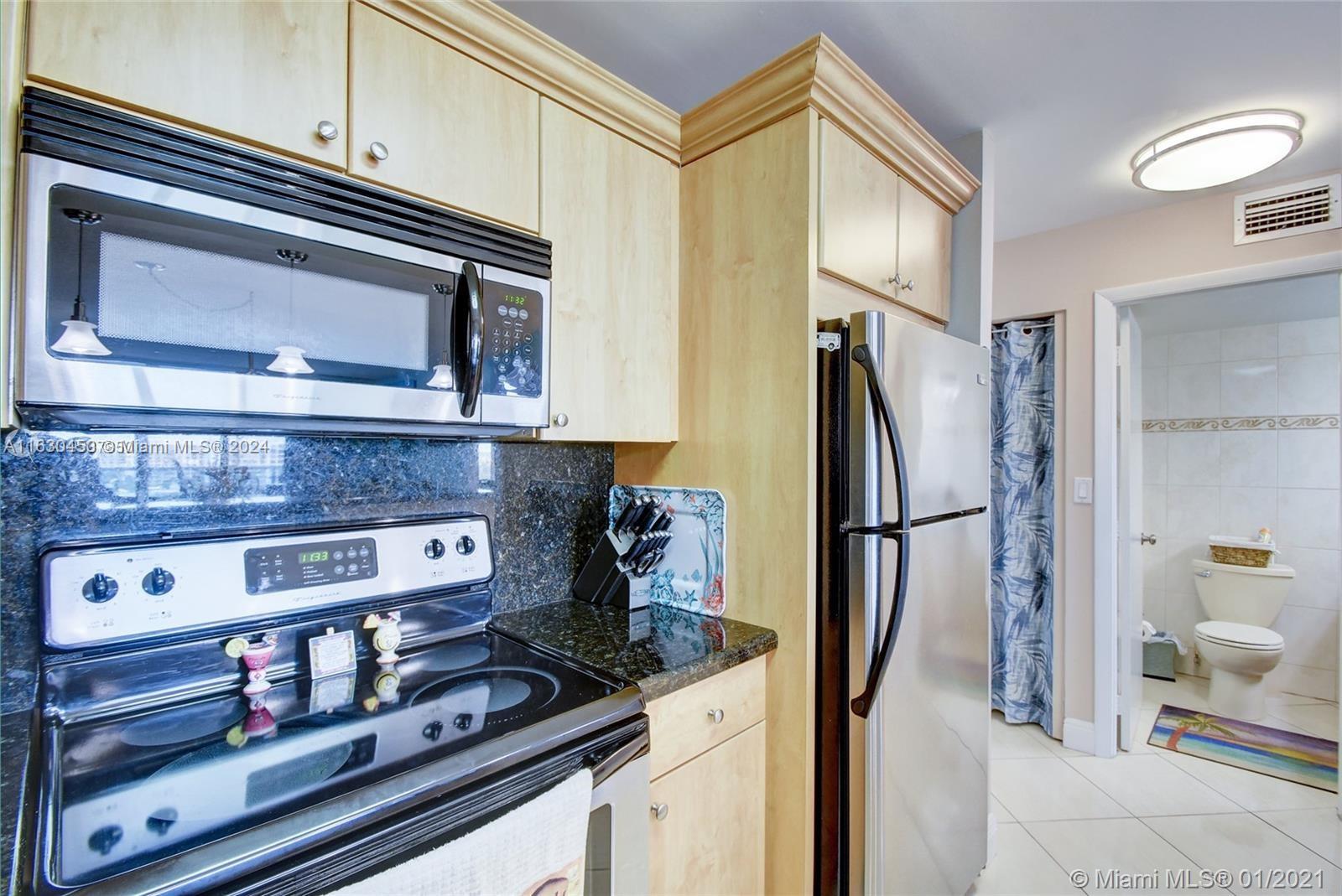 a kitchen with stainless steel appliances granite countertop a refrigerator and a stove