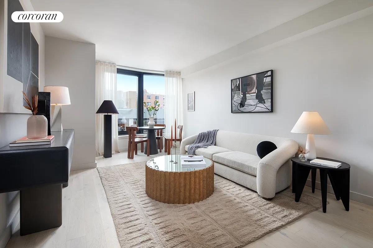 a living room with furniture and a large mirror next to a window