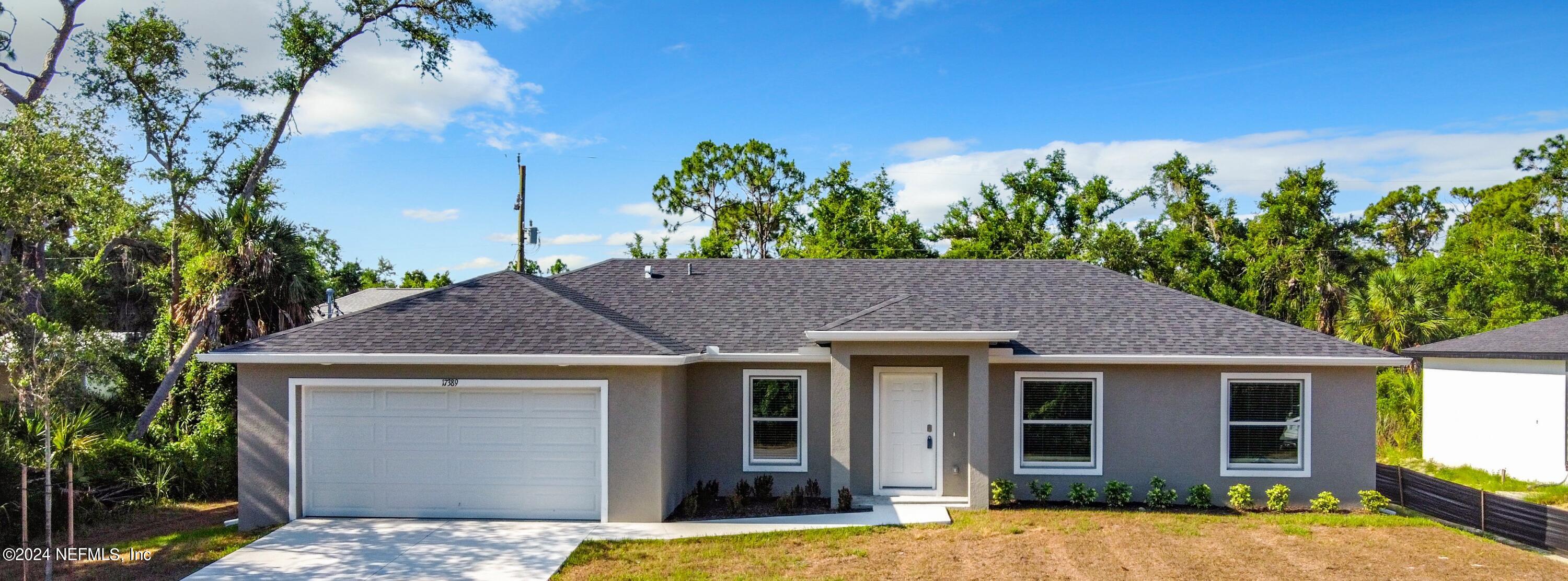 a front view of a house with a yard garage and outdoor seating