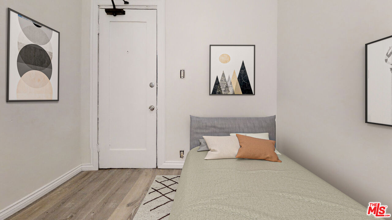 a bedroom with a bed and a painting on the wall