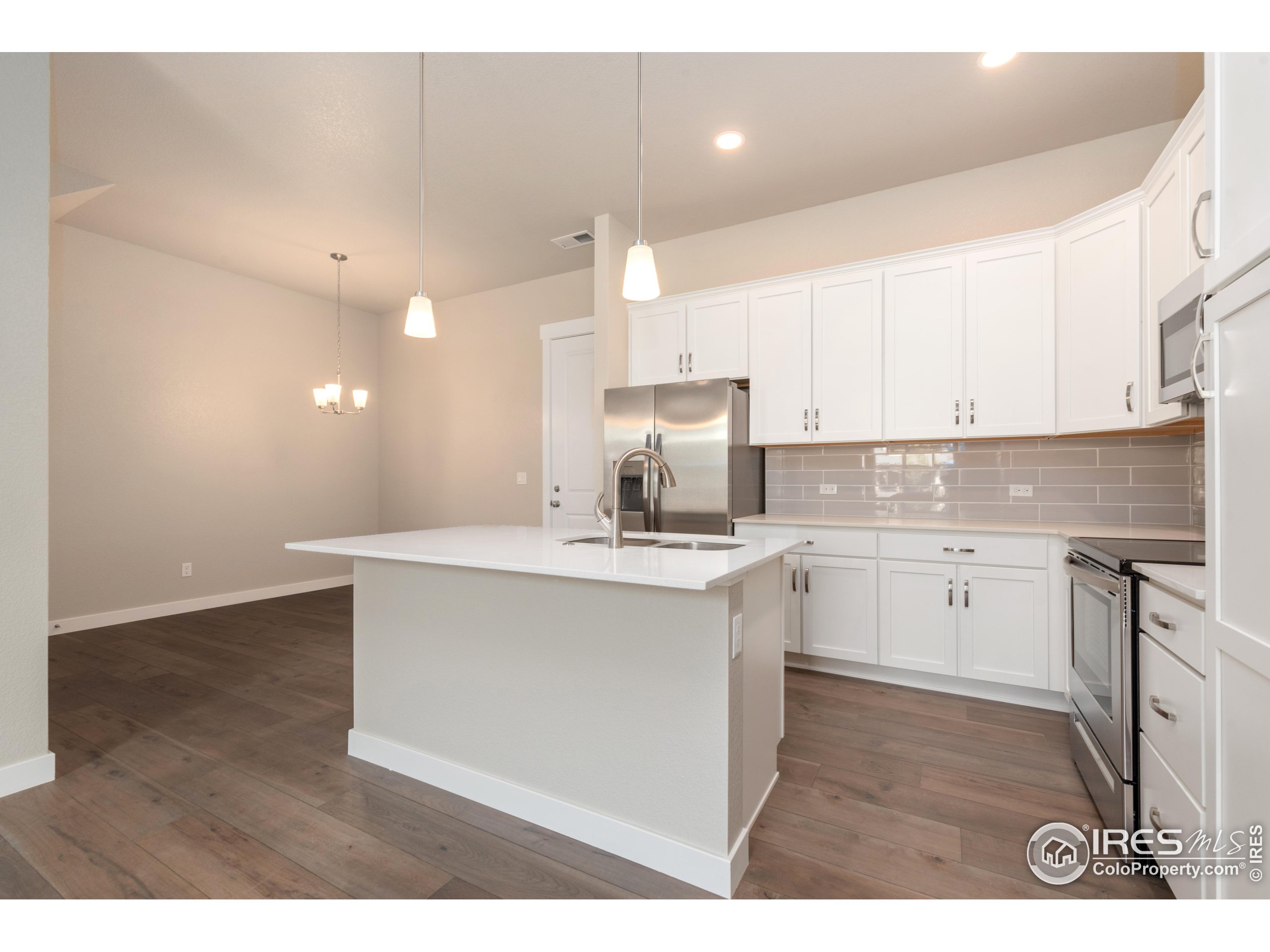 a kitchen with kitchen island sink stove and cabinets