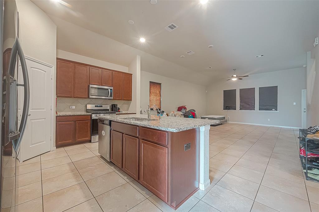 a kitchen with granite countertop a sink counter top space appliances and cabinets