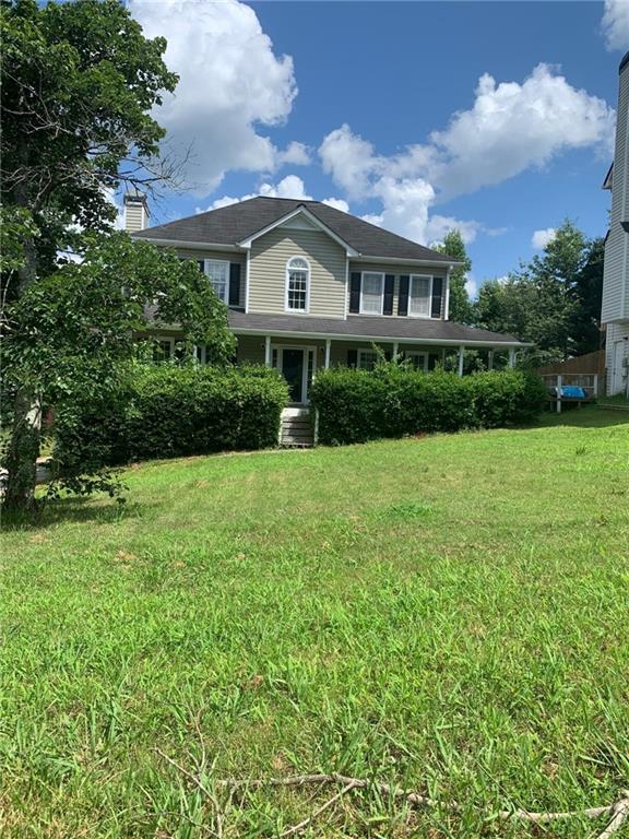 a front view of house with yard and green space