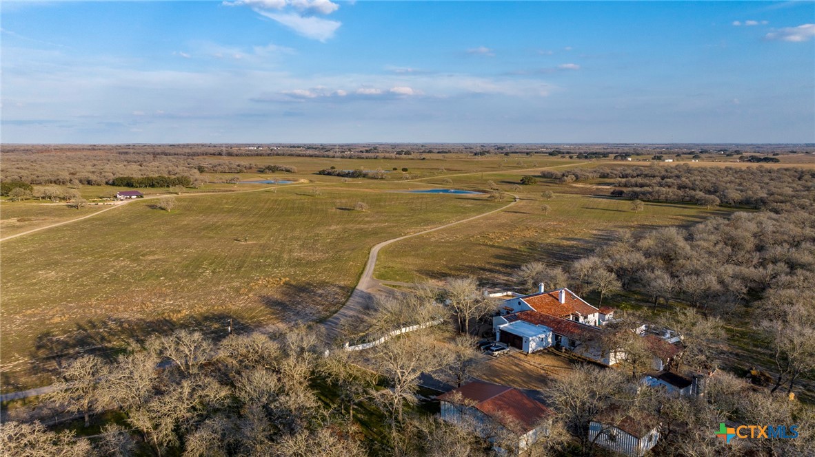 an aerial view of ocean and residential houses with outdoor space