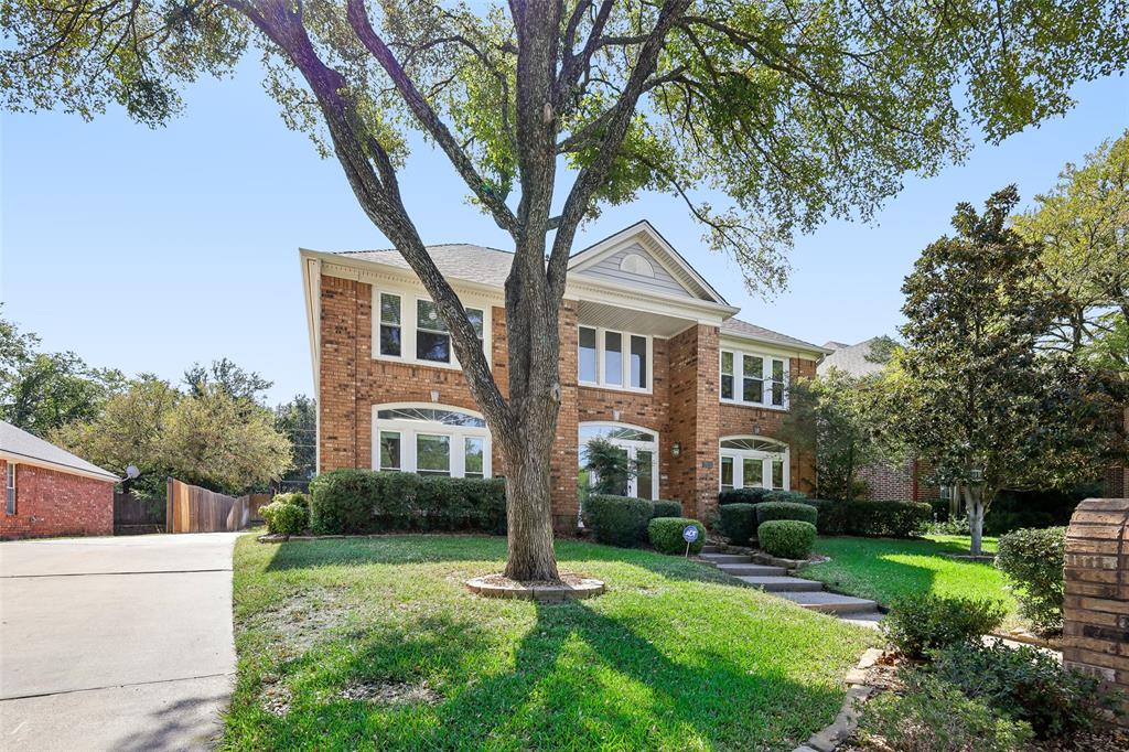 a front view of a house with a yard and trees