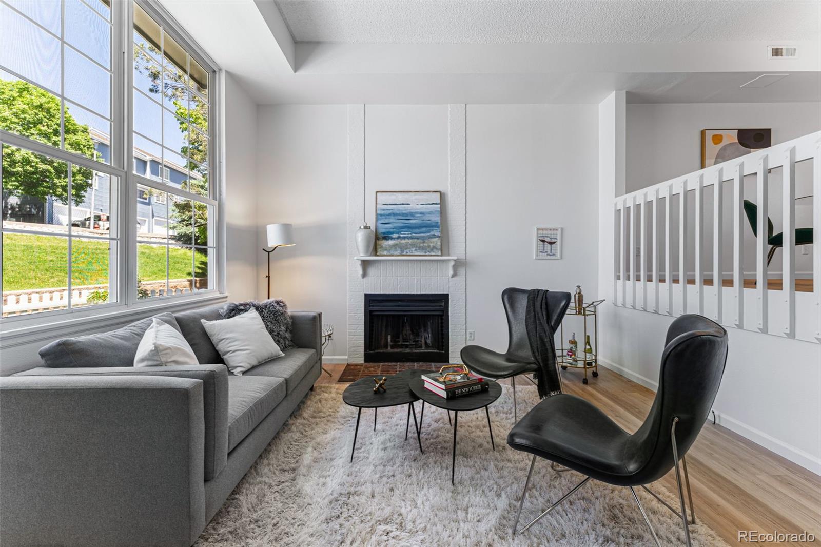 a living room with furniture fireplace and a large window