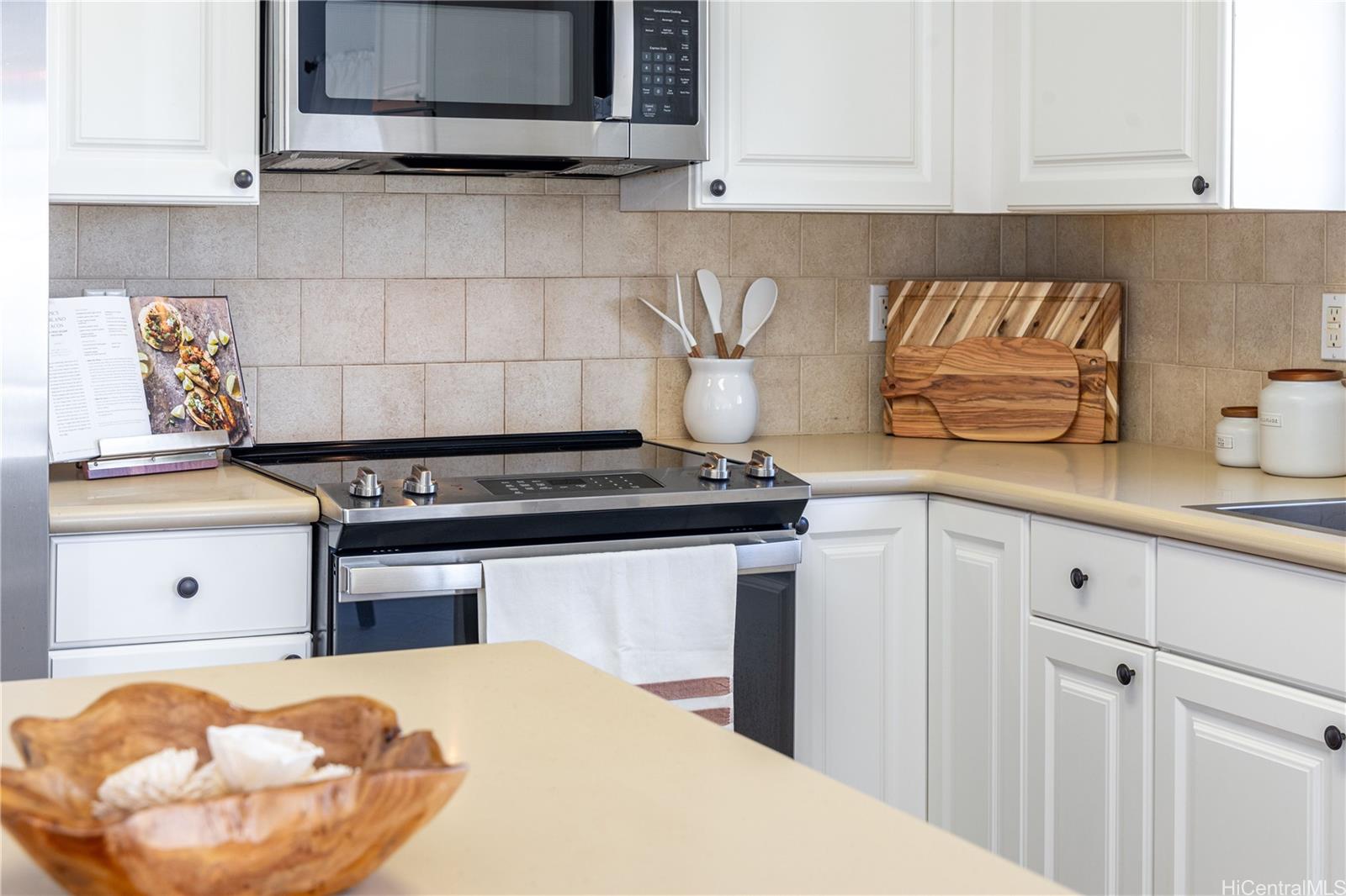 a kitchen with stainless steel appliances granite countertop a stove and a white cabinets