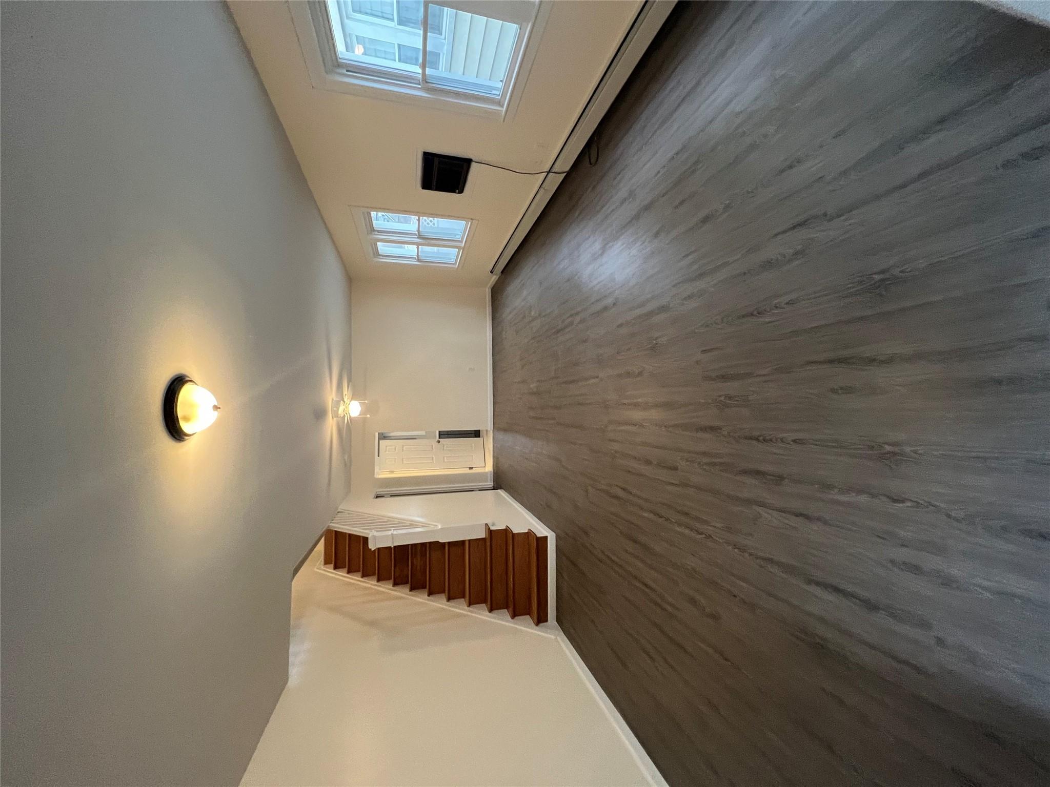 Unfurnished living room with a baseboard heating unit and dark wood-type flooring