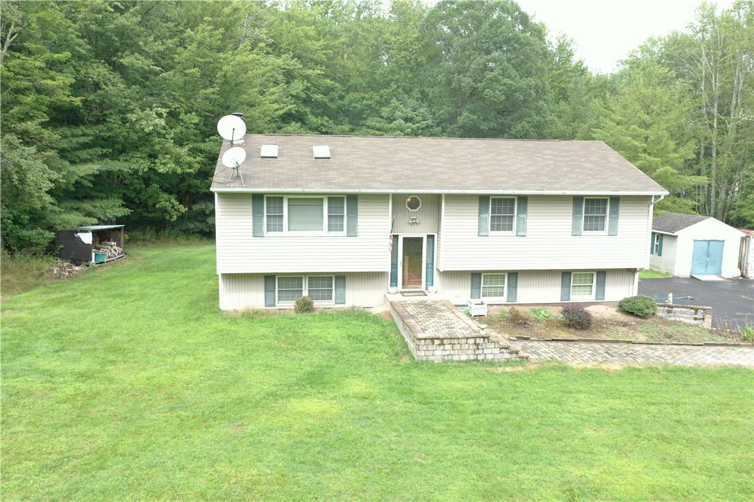 Raised ranch with a storage shed and a front yard