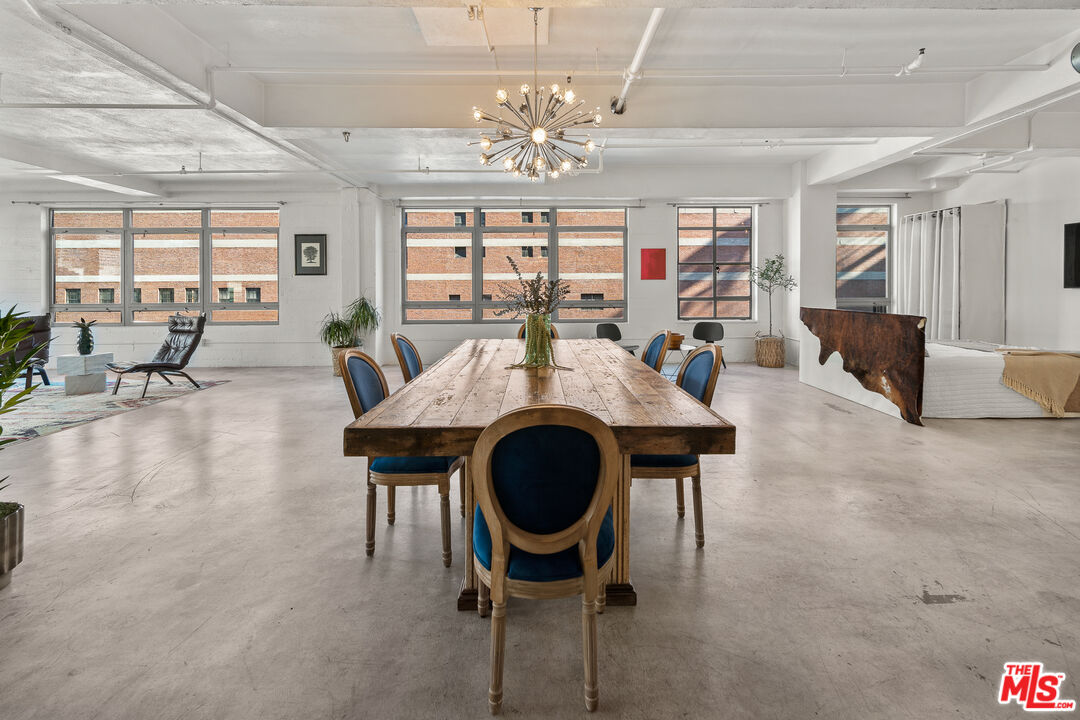 a living room with furniture a chandelier and a large window