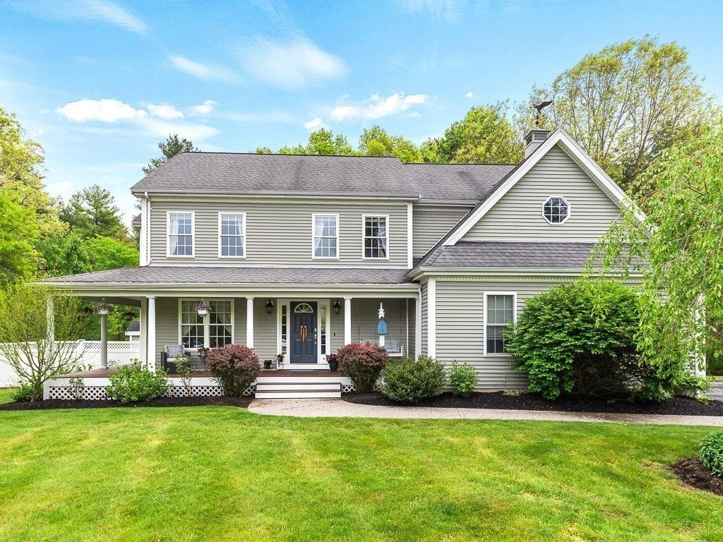 a front view of a house with a garden and trees