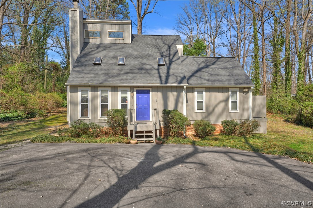 a front view of a house with a yard and tree s