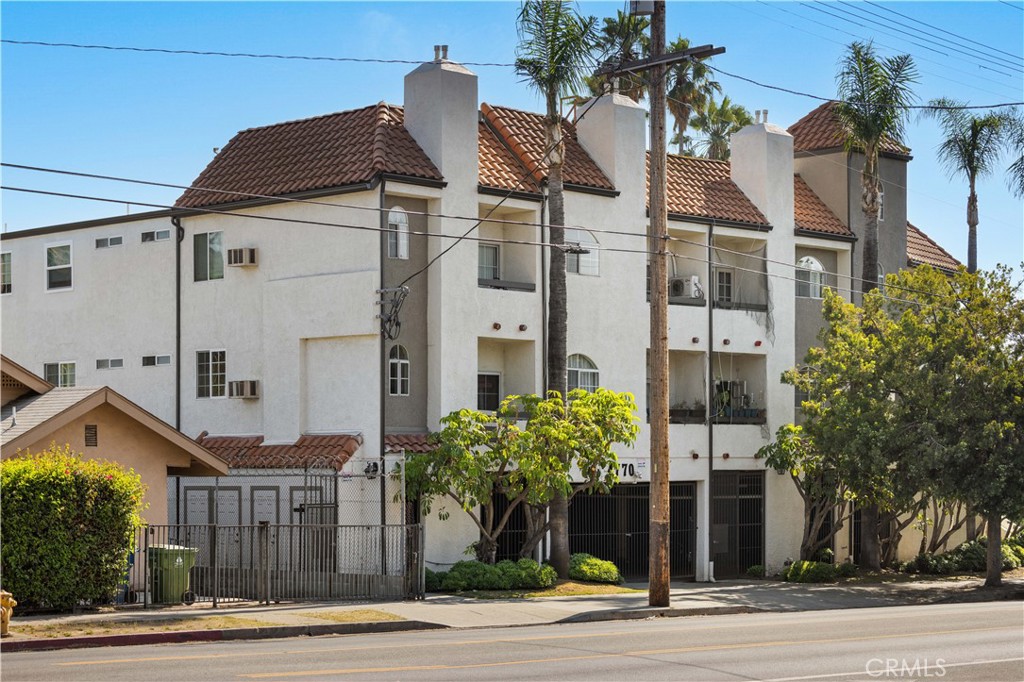 a view of a white building among the street and palm trees