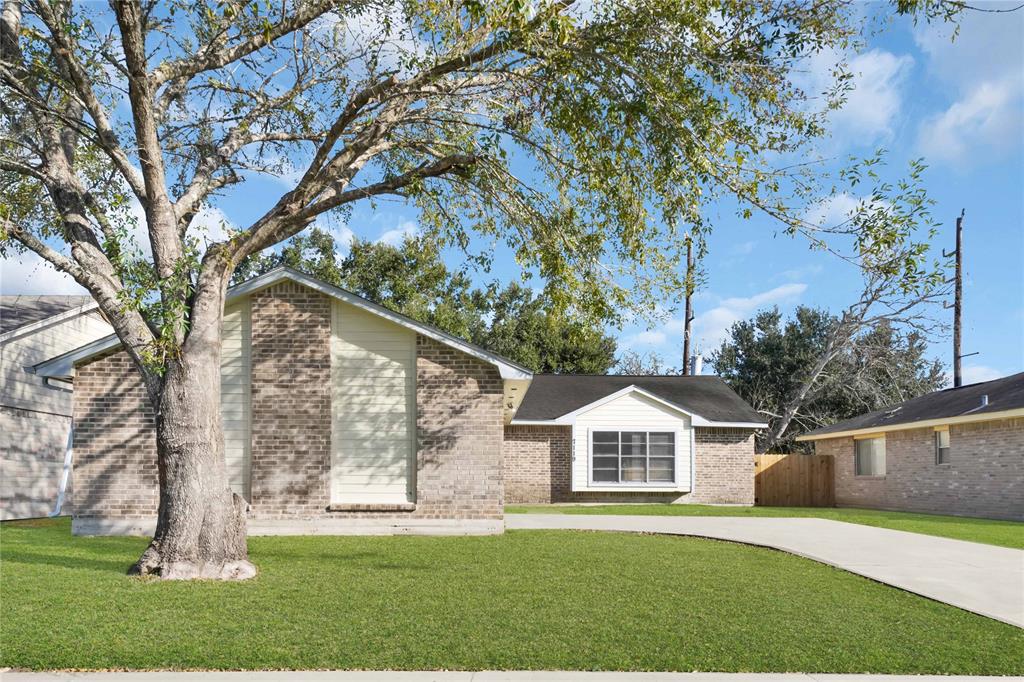 a front view of a house with a yard and trees