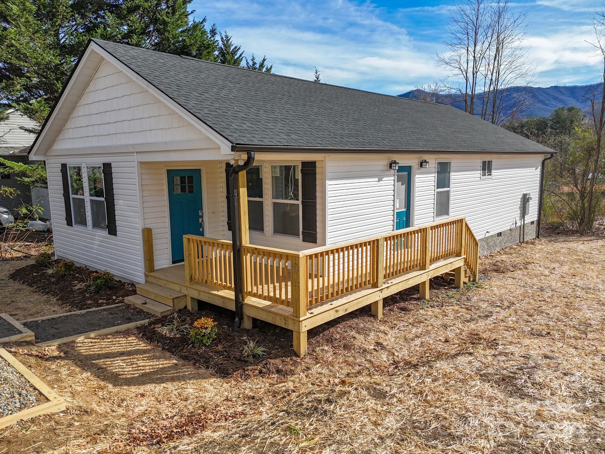 a view of a house with a yard and wooden fence