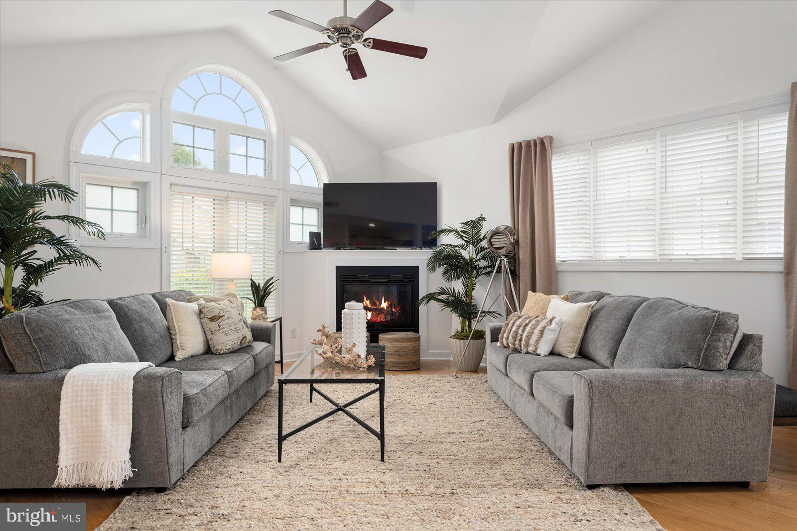 a living room with furniture a large window and a fireplace