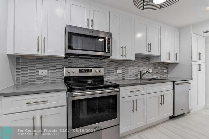 a kitchen with white cabinets stainless steel appliances and sink