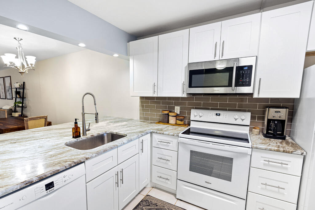 a kitchen with white cabinets and appliances