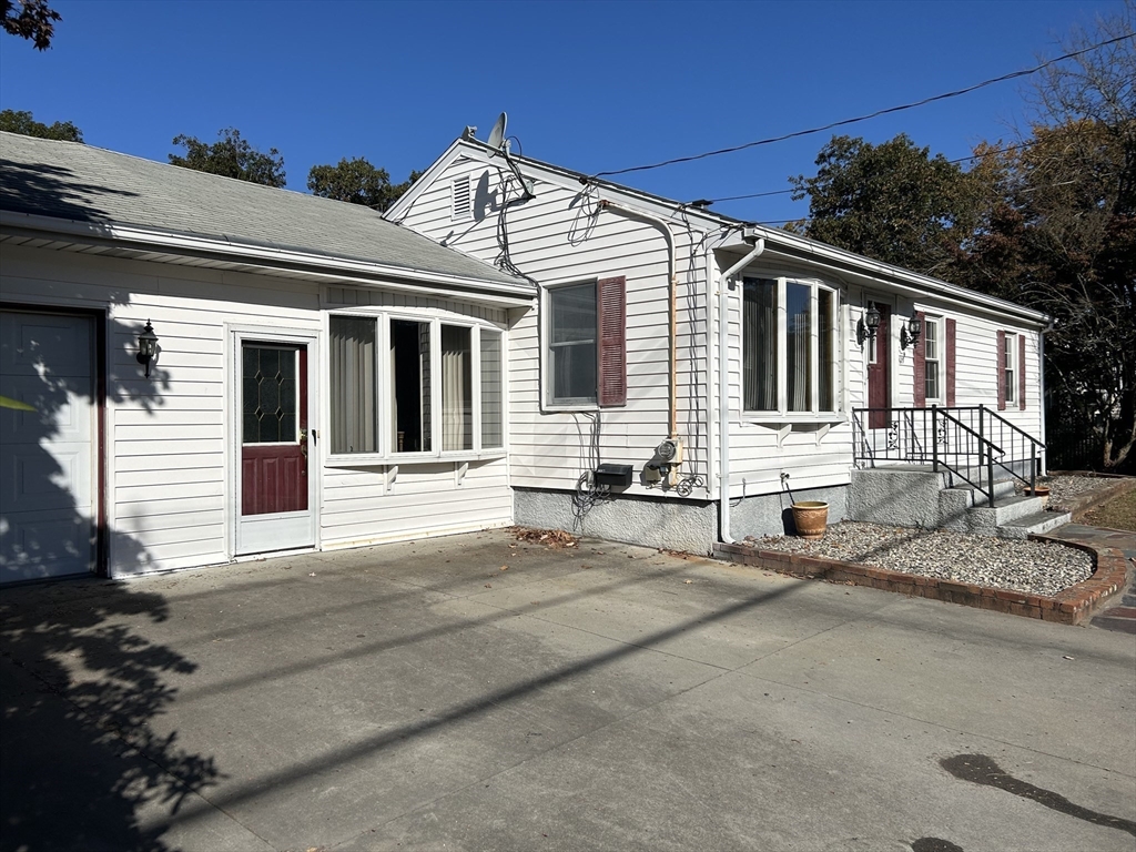 a front view of a house with yard and parking space